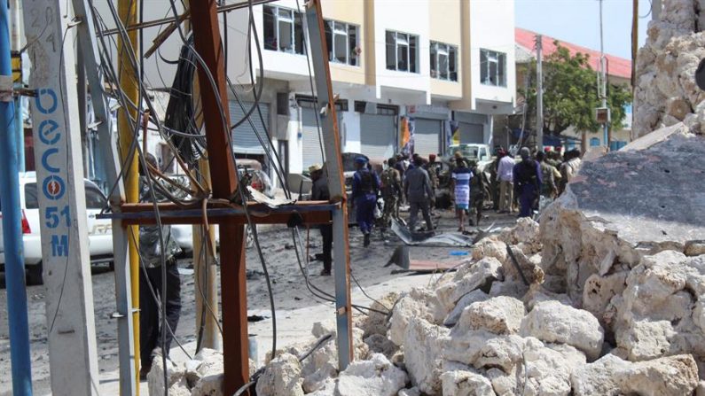 Entulhos são vistos quando as pessoas se reúnem no local de uma explosão de um carro bomba em um posto de controle perto do parlamento em Mogadíscio, Somália, 08 de janeiro de 2019. Pelo menos quatro pessoas foram mortas em um último ataque reivindicado pelo grupo militante islâmico da Somália al-Shabab (EFE / EPA / SAID YUSUF WARSAME)