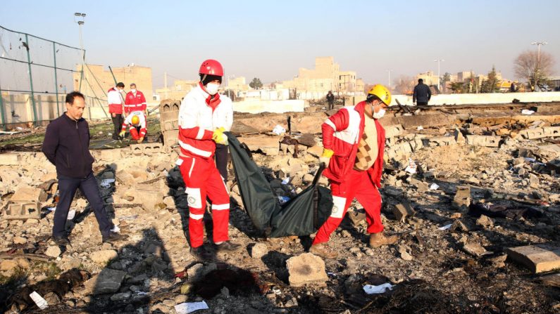 Los equipos de rescate recuperan un cuerpo después de que un avión ucraniano que transportaba 176 pasajeros se estrellara cerca del aeropuerto Imam Jomeini de la capital iraní, Teherán, a primera hora de la mañana del 8 de enero de 2020, matando a todos los que iban a bordo. (AFP vía Getty Images)