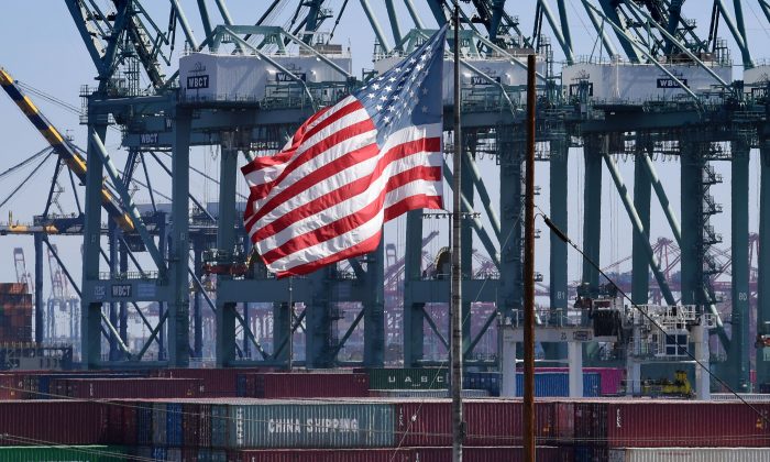 La bandera de los Estados Unidos ondea sobre los contenedores de envío chinos que se descargaron en el puerto de Long Beach, en el condado de Los Ángeles, el 29 de septiembre de 2018. (Mark Ralston / AFP / Getty Images)