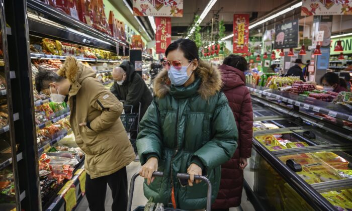 Una mujer china usa una mascarilla protectora y gafas de sol mientras hace las compras en un supermercado de Beijing el 28 de enero de 2020. (Kevin Frayer/Getty Images)
