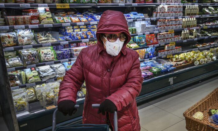 Una mujer china usa una máscara protectora y gafas de sol mientras hace la compra en un supermercado de Beijing, China, el 28 de enero de 2020. (Kevin Frayer/Getty Images)