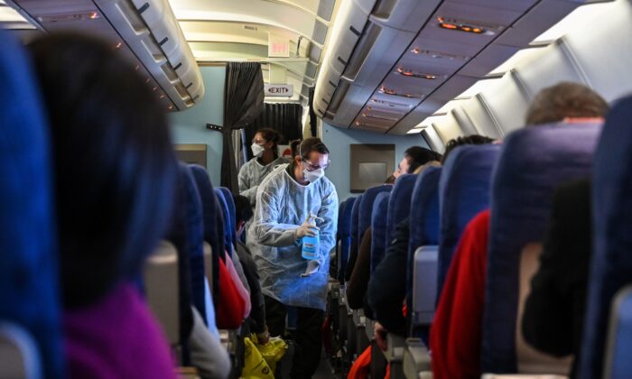 Un integrante de la tripulación de un vuelo de evacuación de ciudadanos franceses desde Wuhan da a los pasajeros un desinfectante durante el vuelo a Francia el 1 de febrero de 2020. (Hector Retamal/AFP vía Getty Images)