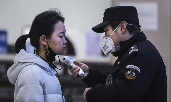 El personal de seguridad comprueba la temperatura de los pasajeros en el muelle del río Yangtze en Wuhan, provincia de Hubei, China, el 22 de enero de 2020. (Getty Images)