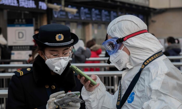 Personal de seguridad lleva ropa protectora para ayudar a detener la propagación de un virus mortal que comenzó en Wuhan, en la entrada de una estación de metro en Beijing, el 27 de enero de 2020. (Nicolas Asfouri/AFP vía Getty Images)