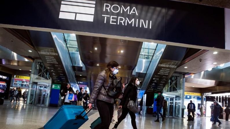 Pasajeros con mascarillas transitan por la estación Termini, en Roma. EFE/EPA/ANGELO CARCONI
