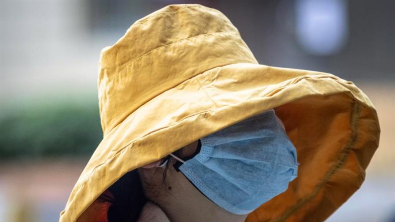 Una mujer con una máscara protectora camina por las calles de Guangzhou, provincia de Guangdong (China), 17 de febrero de 2020. (Imagen EFE/EPA/ALEX PLAVEVSKI)
