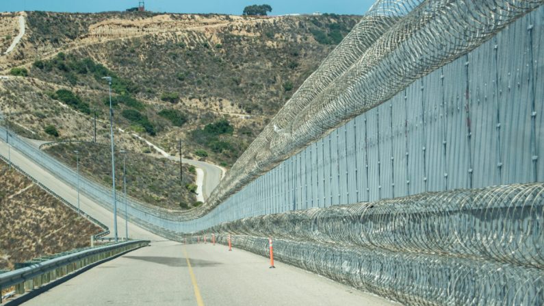 La cerca secundaria de la frontera entre Estados Unidos y México se encuentra cerca de un área conocida popularmente como "Smuggler's Gulch", en San Diego el 12 de julio de 2017. La Patrulla Fronteriza agregó una segunda capa de cable de concertina a lo largo del fondo de la cerca que ayuda a reducir los asaltos en agentes. (Joshua Philipp/The Epoch Times)