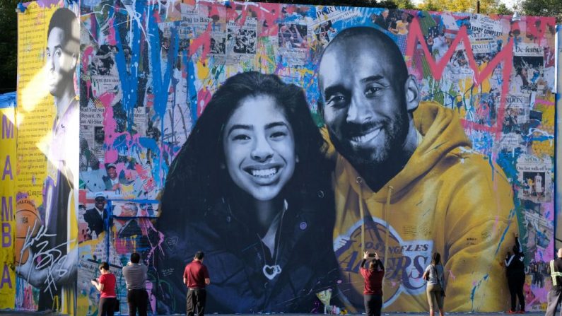 La gente se detiene para tomar fotos frente al nuevo mural del artista francés Mr. Brainwash que representa a Kobe Bryant y su hija Gigi en Los Ángeles el 31 de enero de 2020. (Chris Delmas/ AFP/Getty Images)