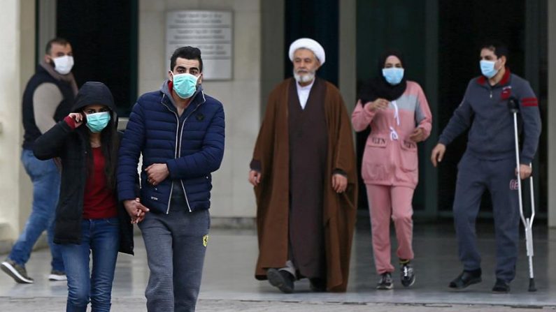 Las personas usan máscaras faciales mientras caminan fuera del Hospital Universitario Rafik Hariri, donde una mujer es tratada por coronavirus, el primer caso en Beirut, Líbano, el 21 de febrero de 2020. EFE / EPA / WAEL HAMZEH