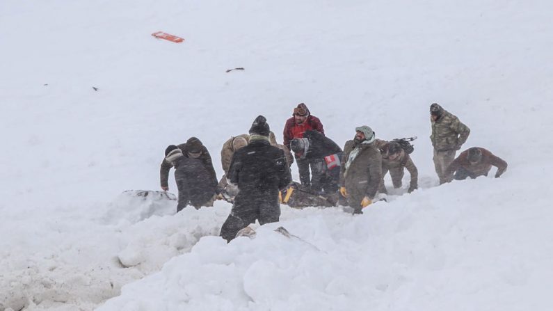 Oficiales de seguridad y aldeanos llevan a una víctima de una avalancha cerca de la ciudad de Bahcesehir, en la provincia de Van, en el este de Turquía, el 5 de febrero de 2020. (DHA / AFP / Getty Images)