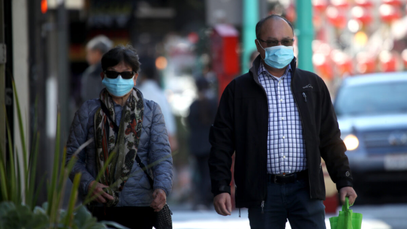Las personas usan máscaras quirúrgicas mientras caminan por la avenida Grant de Chinatown en San Francisco, California, el 26 de febrero de 2020. (Justin Sullivan/Getty Images)