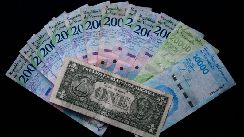 Imagen de un billete de un dólar estadounidense y su equivalente promedio en moneda venezolana (32,000 bolívares) tomada en Caracas, Venezuela el 20 de noviembre de 2019. (YURI CORTEZ / AFP / Getty Images)