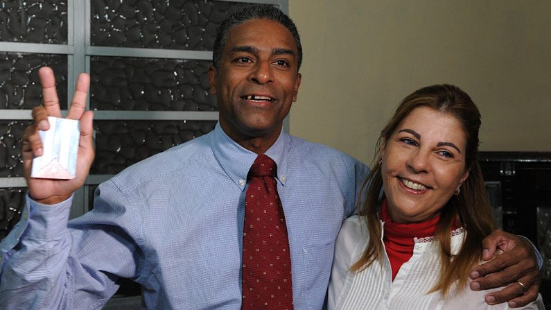 El disidente cubano Óscar Elias Biscet (i) muestra el signo "v" mientras abraza a su esposa Elsa Morejon (d), pocos minutos después de su liberación de la cárcel, el 11 de marzo de 2011. Biscet es uno de los líderes opositores más duros en Cuba y se mantuvo en la cárcel desde 2003. (ADALBERTO ROQUE / AFP / Getty Images)