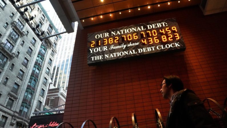 Un hombre pasa junto al reloj de la deuda nacional en la calle 43 en el centro de la ciudad de Nueva York el 15 de febrero de 2019. (TIMOTHY A. CLARY/AFP/Getty Images)