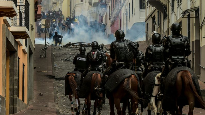 La policía montada se enfrenta a los manifestantes durante los enfrentamientos en Quito mientras miles de personas marchan en Ecuador el 9 de octubre de 2019. (Foto de RODRIGO BUENDIA/AFP vía Getty Images)