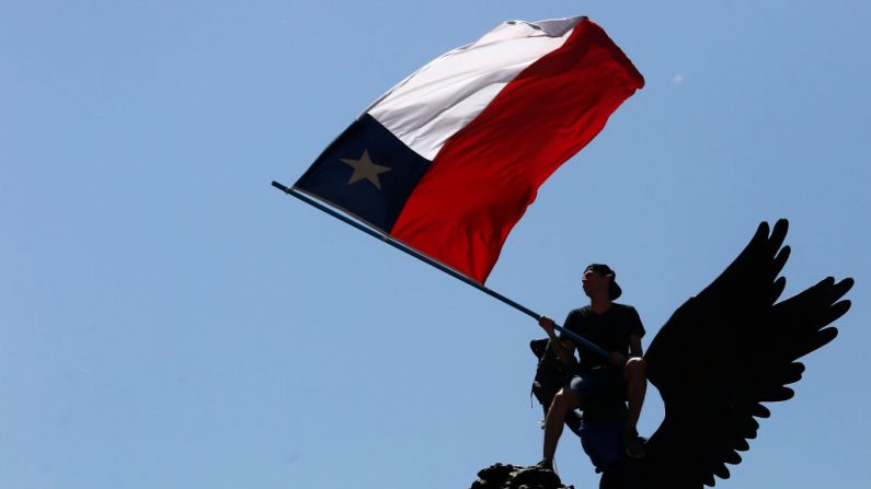 Un manifestante agita una bandera chilena en la cima de un monumento en Santiago de Chile. (Foto de Marcelo Hernandez/Getty Images)
