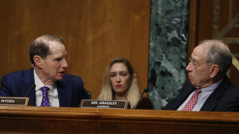 El Senador Ron Wyden (D-Ore.) (izq.) habla con el Presidente Chuck Grassley (R-Iowa) durante una audiencia del Comité de Finanzas del Senado, en el Capitolio de EE.UU., el 24 de octubre de 2019. (Mark Wilson/Getty Images)