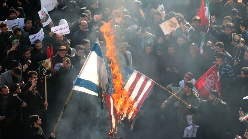 Iraníes incendian banderas de Estados Unidos e Israel durante una procesión en Teherán, capital de Irán el 6 de enero de 2020 (ATTA KENARE/AFP a través de Getty Images)