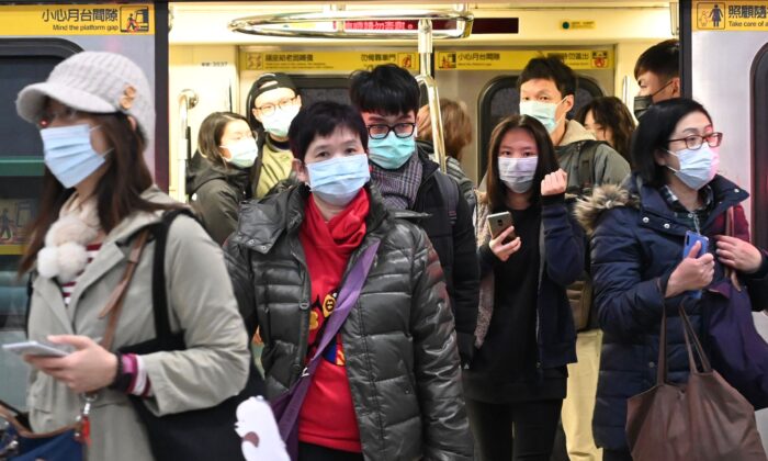 Viajeros con mascarillas se bajan de un tren en una parada del Mass Rapid Transit (MRT) en Taipei, Taiwán, el 30 de enero de 2020. (MISMO YEH/AFP vía Getty Images)