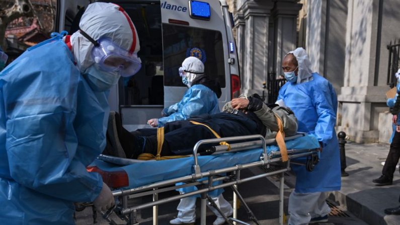 Se ve a personal médico con trajes de protección llevando a un paciente de un apartamento que se sospecha que tiene el nuevo coronavirus, en la provincia de Hubei, el 30 de enero de 2020. (Hector RETAMAL/AFP a través de Getty Images)