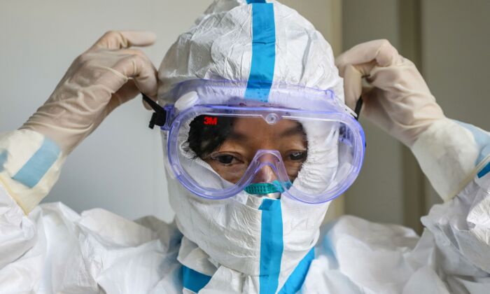 Médico con un par de gafas protectoras antes de ingresar a la sala de aislamiento en un hospital en Wuhan, China, el 30 de enero de 2020. (STR/AFP a través de Getty Images)