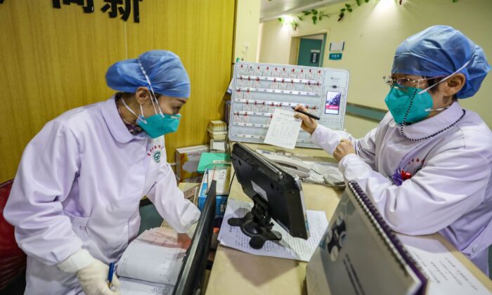 Miembros del personal médico con máscaras faciales hablando en un hospital de Wuhan, China, el 30 de enero de 2020. (STR/AFP a través de Getty Images)
