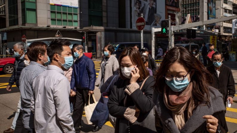 Residentes usan mascarilla quirúrgica al cruzar una calle en un distrito comercial el 31 de enero de 2020 en Hong Kong, China. (Anthony Kwan/Getty Images)