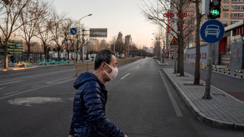 Foto tomada el 31 de enero de 2020, un hombre que lleva una máscara protectora como medida preventiva tras un brote de virus que comenzó en la ciudad china de Wuhan, camina por una calle casi vacía de Beijing. - China (NICOLAS ASFOURI / AFP) (Foto de NICOLAS ASFOURI/AFP vía Getty Images)