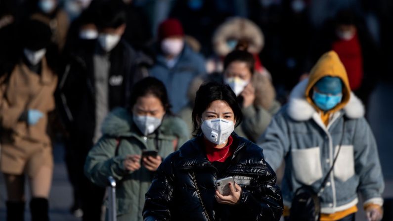 Los viajeros que usan máscaras faciales llegan de varias provincias a la estación de trenes de Beijing el 3 de febrero de 2020. (NOEL CELIS / AFP / Getty Images)