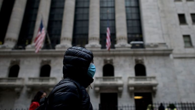Una mujer con una mascarilla pasa por la Bolsa de Nueva York (NYSE) el 3 de febrero de 2020. (Foto de JOHANNES EISELE/AFP vía Getty Images)