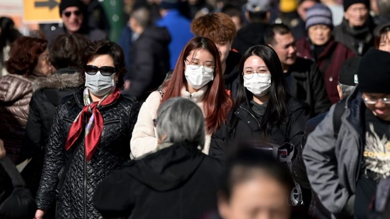 La gente usa máscaras quirúrgicas por temor al coronavirus en Flushing, un barrio del distrito de Queens en la Ciudad de Nueva York, el 3 de febrero de 2020.  (Foto de JOHANNES EISELE/AFP a través de Getty Images)
