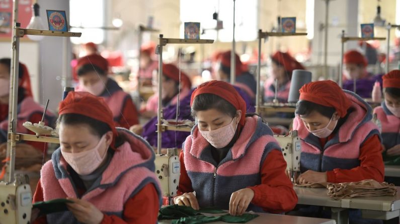 En esta foto tomada el 6 de febrero de 2020, los trabajadores de la Fábrica de Tejidos de Songyo en Pyongyang producen máscaras para la protección contra el nuevo coronavirus. (Foto de KIM WON-JIN/AFP vía Getty Images)
