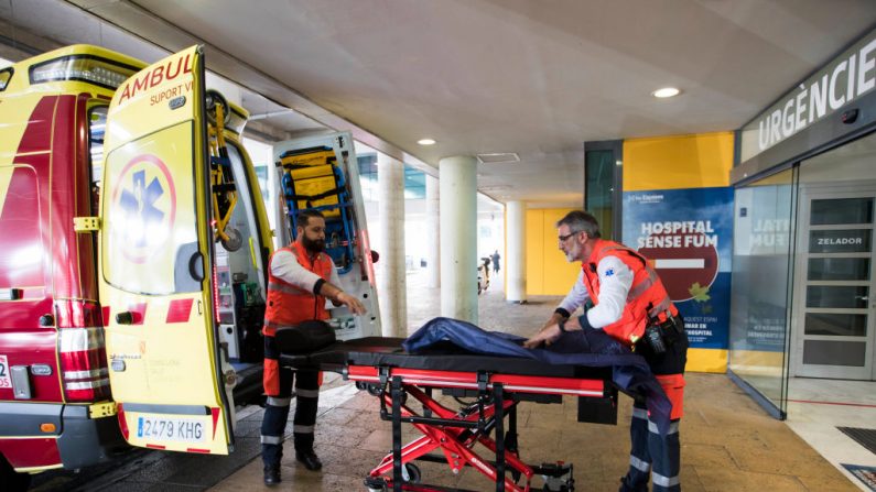 Dos hombres preparan una ambulancia en el exterior del Hospital Universitario en Palma de Mallorca donde un británico ha sido diagnosticado con un coronavirus, el 9 de febrero de 2020. (Foto de STRINGER / AFP) (Foto de STRINGER/AFP vía Getty Images)
