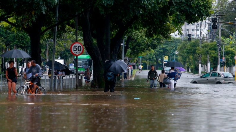 La gente atraviesa una calle inundada después de lluvias torrenciales en Sao Paulo, Brasil, el 10 de febrero de 2020. (MIGUEL SCHINCARIOL / AFP / Getty Images)
