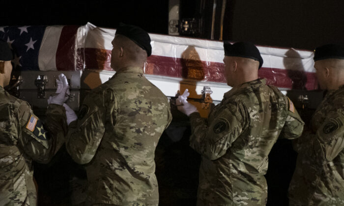 El personal militar levanta una caja de traslado para un miembro caído del servicio, Sargento del Ejército de los EE.UU. de primera clase Antonio R. Rodríguez, 28, durante una ceremonia digna en la Base de la Fuerza Aérea de Dover, en Dover, Del., el 10 de febrero de 2020. (Mark Makela/Getty Images)
