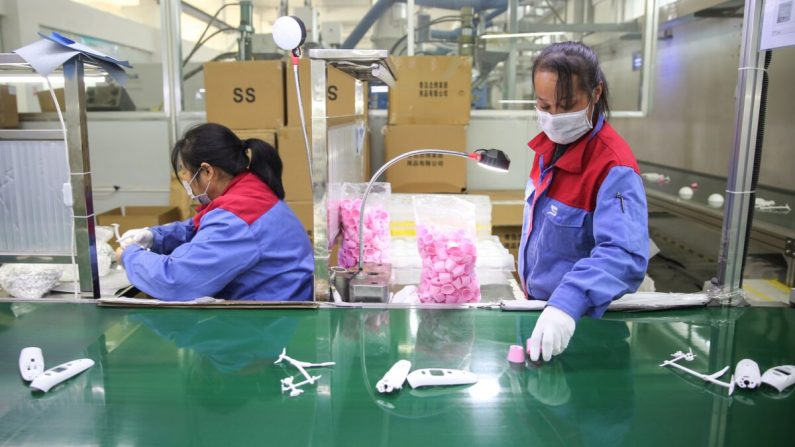 Trabajadoras produciendo termómetros en una fábrica de la provincia de Shandong, China, el 10 de febrero de 2020. (STR/AFP vía Getty Images)