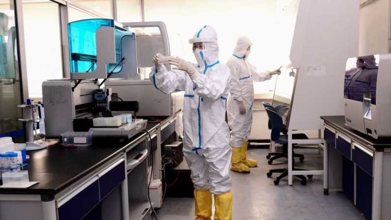 Técnicos de laboratorio trabajan en el análisis de muestras de personas para detectar el COVID-19 en un laboratorio de Shenyang, en la provincia nororiental de Liaoning, China, el 12 de febrero de 2020. (Foto de STR/AFP a través de Getty Images)