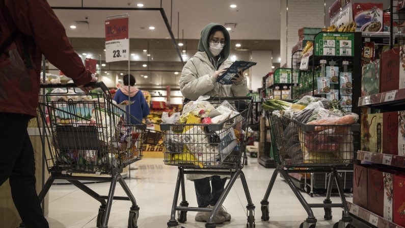 Una mujer usa una máscara protectora mientras compra en el supermercado el 12 de febrero de 2020 en Wuhan, provincia de Hubei, China.(Stringer/Getty Images)