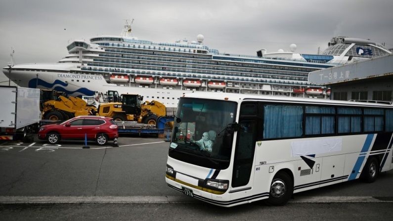 Un autobús con un conductor cubierto de un equipo de protección completo sale del muelle junto al crucero Diamond Princess, que tiene alrededor de 3600 personas en cuarentena a bordo debido a los temores del nuevo coronavirus COVID-19, en la Terminal de Cruceros del Muelle Daikoku en el puerto de Yokohama el 14 de febrero de 2020. (Foto de CHARLY TRIBALLEAU/AFP vía Getty Images)