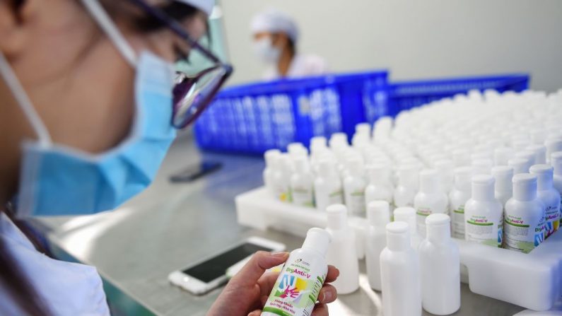 Un trabajador fabrica desinfectante de manos en una fábrica en Hanoi el 14 de febrero de 2020 en medio de la preocupación por el brote de coronavirus COVID-19. (NHAC NGUYEN/AFP vía Getty Images)