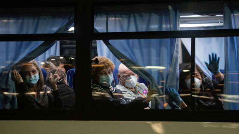 Ciudadanos estadounidenses saludan desde un autobús cuando salen del crucero Diamond Princess en cuarentena en el muelle de Daikoku para ser repatriados a los Estados Unidos el 17 de febrero de 2020 en Yokohama, Japón. (Carl Court/Getty Images)