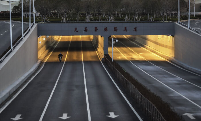Un hombre va en bicicleta por una calle vacía del Optical Valley en Wuhan, China, el 16 de febrero de 2020. (Getty Images)