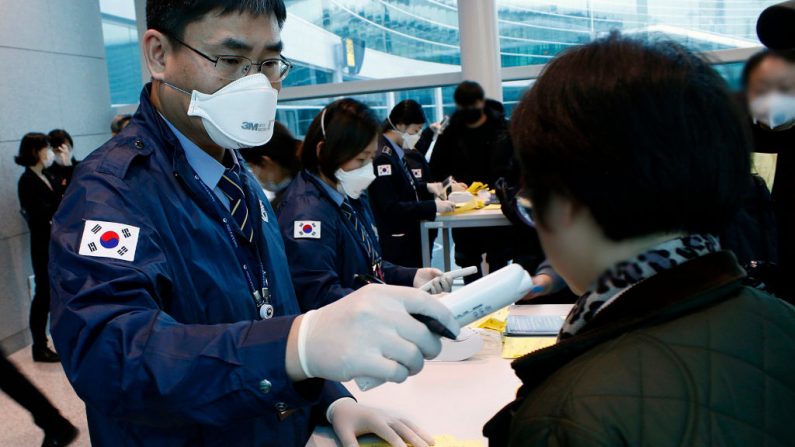 En esta imagen proporcionada por los Centros de Corea del Sur para el Control y la Prevención de Enfermedades   el oficial revisa a los pasajeros de un vuelo de Wuhan que salió del aeropuerto internacional de Incheon el 22 de enero de 2020 en Incheon, Corea del Sur.  (Foto de los Centros Coreanos para el Control y la Prevención de Enfermedades vía Getty Images)
