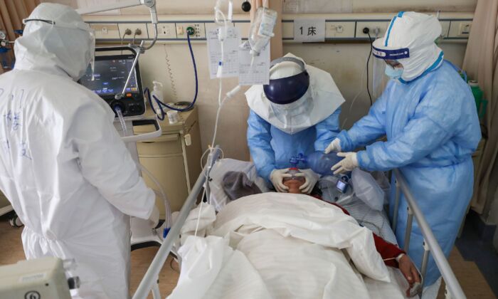 Miembros del personal médico tratan a un paciente infectado por el coronavirus COVID-19 en el Hospital de la Cruz Roja de Wuhan, en la provincia de Hubei, China, el 16 de febrero de 2020. (STR/AFP vía Getty Images)