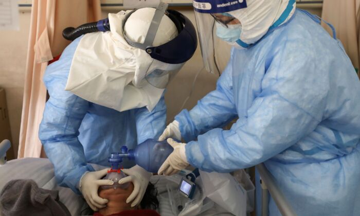 El personal médico está tratando a un paciente infectado por el coronavirus COVID-19 en el Hospital de la Cruz Roja de Wuhan, en Wuhan, China, el 16 de febrero de 2020. (TR/AFP a través de Getty Images)