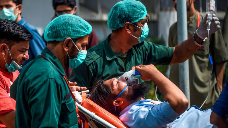 El personal de los paramédicos trasladó a un paciente en una camilla al hospital de Karachi el 18 de febrero de 2020, luego de que una fuga de gas tóxico mató a varias personas y afectó a docenas más en una zona residencial costera en la ciudad portuaria de Karachi, Pakistán. (RIZWAN TABASSUM / AFP / Getty Images)