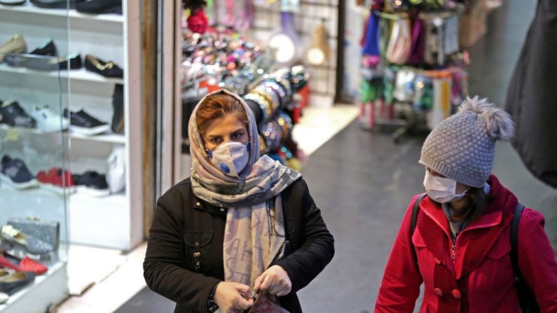 Mujeres iraníes con máscaras protectoras caminan en una calle de la capital Teherán el 20 de febrero de 2020. (ATTA KENARE/AFP vía Getty Images)