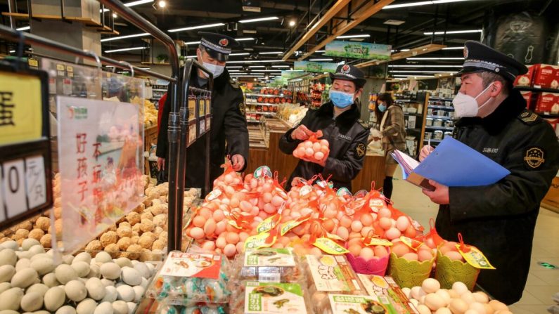 Esta foto tomada el 20 de febrero de 2020 muestra que la supervisión del mercado administra la verificación de huevos en un supermercado mientras monitorean el precio de los productos durante el brote de coronavirus COVID-19 en Huaibei, en la provincia oriental china de Anhui. (STR/AFP a través de Getty Images)