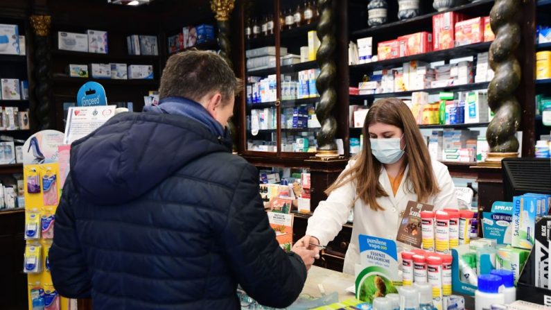 Una farmacéutica que usa una máscara respiratoria protectora atiende a un cliente en Codogno, al sureste de Milán, Italia, el 22 de febrero de 2020. (MIGUEL MEDINA/AFP/Getty Images)