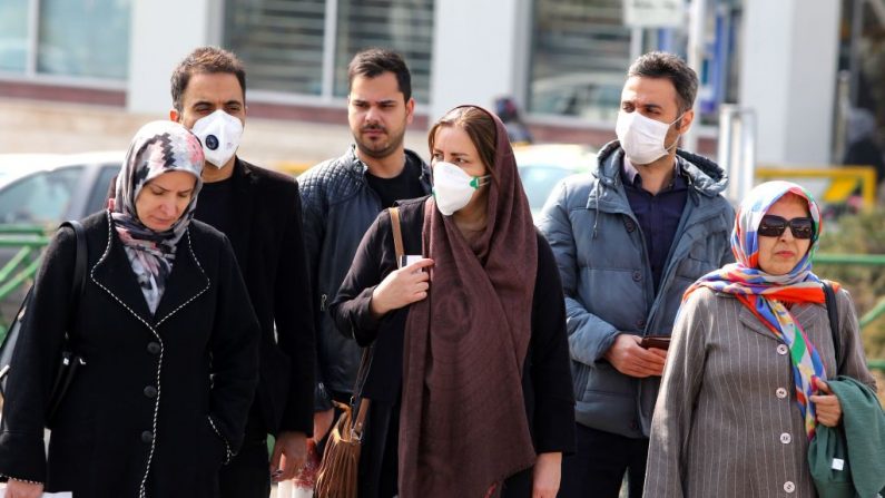 Los iraníes, algunos con máscaras protectoras, esperan para cruzar una calle de la capital Teherán (Irán) el 22 de febrero de 2020. (ATTA KENARE/AFP vía Getty Images)